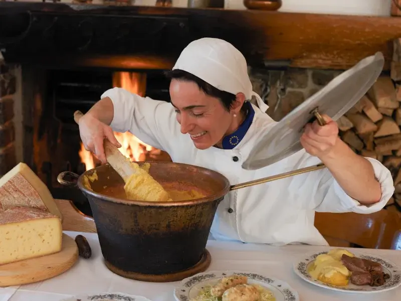 Chef che prepara la polenta nel paiolo di rame davanti al camino del Ristorante Miola Chef che prepara la polenta nel paiolo di rame davanti al camino del Ristorante Miola